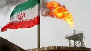 FILE PHOTO: A gas flare on an oil production platform in the Soroush oil fields is seen alongside an Iranian flag in the Gulf