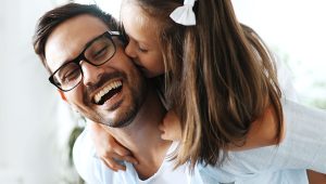Portrait of father and daughter playing at home together