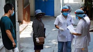 healthcare-workers-talk-to-a-local-resident-near-the-house-of-a-coronavirus-disease--covid-19--patient-as-they-investigate-infection-links-in-hanoi-1