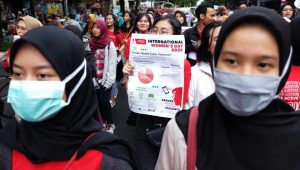 Peserta mengikuti aksi peringatan International Womens Day saat pelaksanaan Hari Bebas Kendaraan Bermotor atau Car Free Day di Solo, Jawa Tengah, Minggu (8/3/2020).