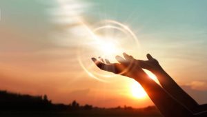 Woman hands praying for blessing from god on sunset background
