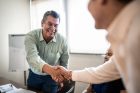 Coworkers greeting and doing a handshake at work
