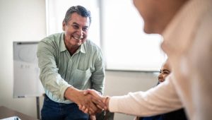 Coworkers greeting and doing a handshake at work