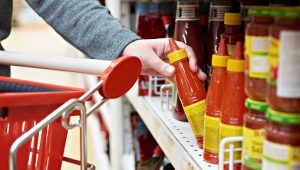 Hot chili sauce in the hands of the buyer at the grocery store